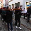 Schülerinnen tragen ein großes Holzkreuz durch die Altstadt von Regensburg