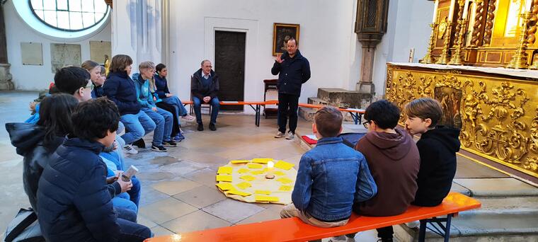 Jugendliche sitzen im Kreis in einer Kirche