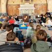 ein Kindergottesdienst im Sitzen auf dem Boden in einer Kapelle
