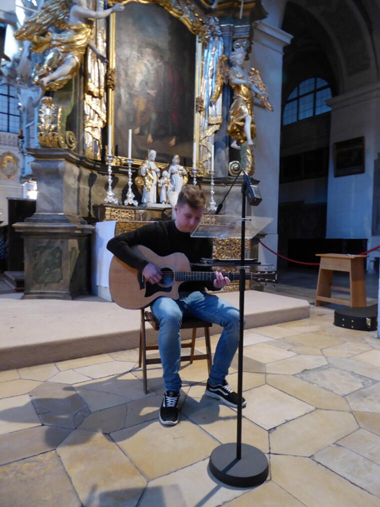 Jugendlicher mit Guitarre in der Kirche