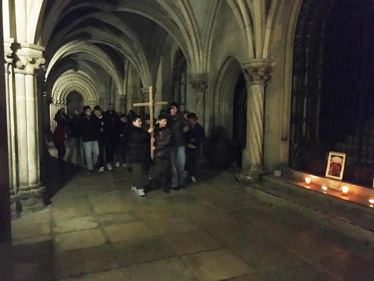 Kinder tragen ein Holzkreuz durch den Schlosskreuzgang von St. Emmeram in Regensburg