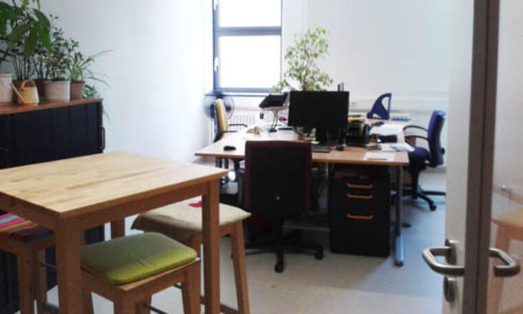 Blick in ein Büro mit Schreibtischen und einem Stehtisch