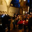 Menschen stehen im Dunkeln mit Kerzen im Vorraum von St. Emmeram