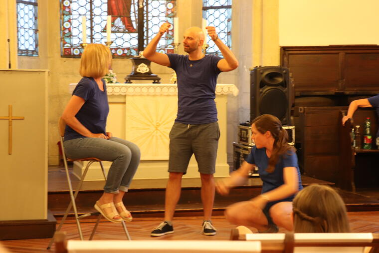 drei Personen machen Improtheater im Altarraum einer Kirche