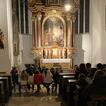 Blick von hinten in einen Kirchenraum mit Besuchern