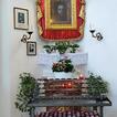 Ein Gnadenbild mit einem dunklen, weinenden Jesus in einer Kirche, mit Rot und Gold eingerahmt