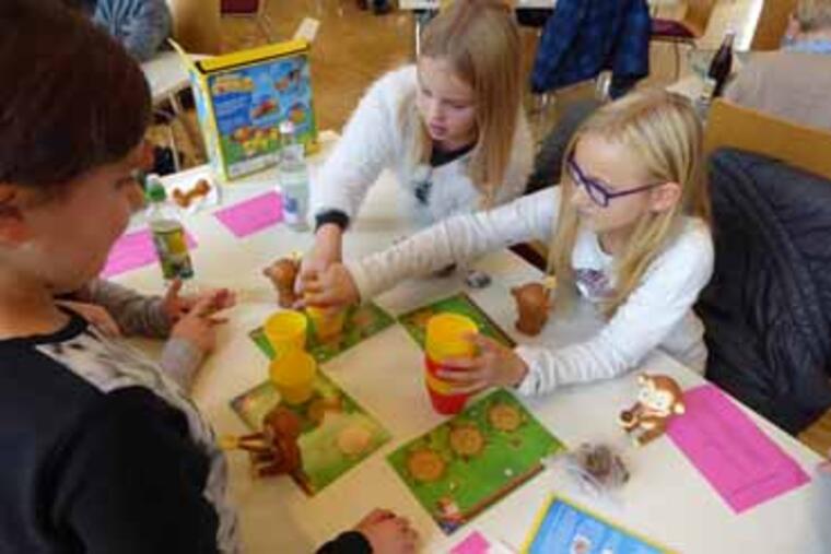 Drei Kinder spielen das  Siegerspiel "Crazy Coconut"