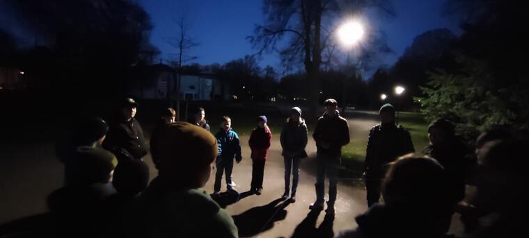 Eine Jugendgruppe unterwegs bei Vollmond in einem Park