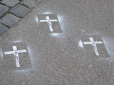 Drei Kreuze in Weiß auf die Straße gesprüht
