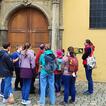 Eine Besuchergruppe aus ca 10 Kindern steht vor dem Eingang zur Niedermünsterkirche in Regensburg