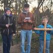 Jugendliche und Kinder stehen auf einem Hügel mit einem Holzkreuz dabei