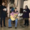 Vier Erwachsene in einer Kirche singen und eine Frau spielt Gitarre