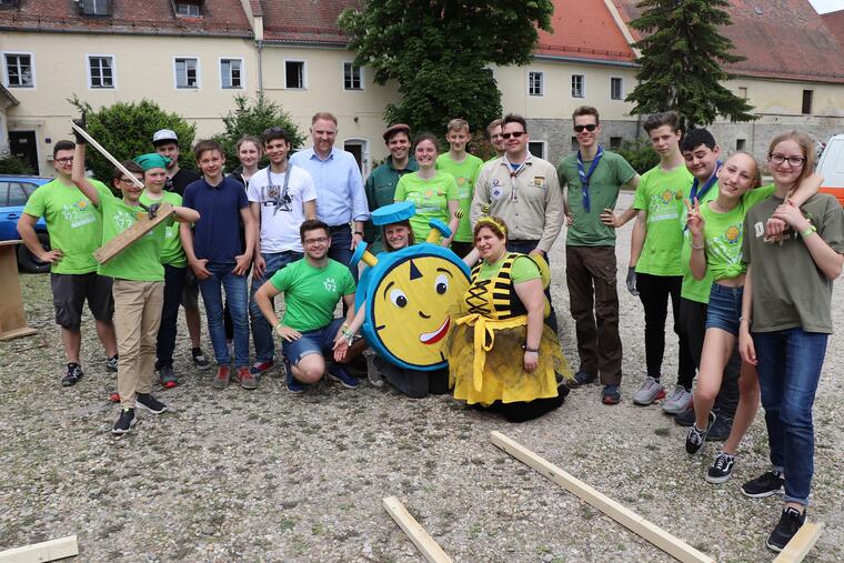 Gruppenbild von jungen Menschen, 2 davon in Kostümen einer Uhr und einer Biene