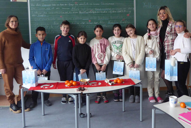 Gruppenfoto Schulkinder mit Lehrerinnen vor Schultafel