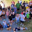 Ein Gruppenfoto von zirka 40 Kinder und ein paar Erwachsenen von einem Geländer aus, Blick nach unten auf die Personen