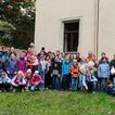 60 Kinder und ein paar Erwachsene in einem Garten bei einem Gruppenfoto.